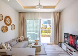 a living room with a couch and a tv at Aqualina B3-2 by HolidayKeys in Kyrenia