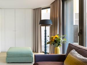 a living room with a blue ottoman and a lamp at LSA Parque by Numa in Lisbon