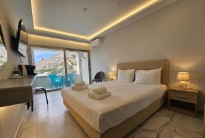 a bedroom with a bed with two towels on it at Pals Studios Pefkos in Pefki