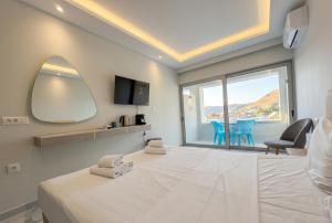 a bedroom with a large bed and a large window at Pals Studios Pefkos in Pefki