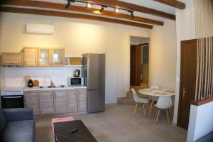 a kitchen with a refrigerator and a table with chairs at Villa Elizabeth Apartments in Ouranoupoli