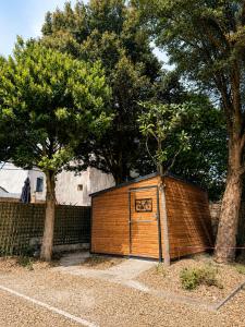 a wooden garage with a gate and two trees at Le Grand Hôtel de Mayenne - Logis hôtels restaurant in Mayenne