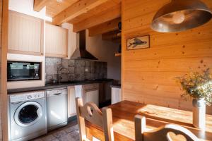 a kitchen with a table and a washing machine at Le chalet d'en ô in Les Clefs