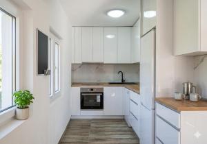 a kitchen with white cabinets and a window at Отрада in Utjeha