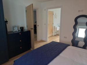 a bedroom with a bed and a dresser and a mirror at Ives End in Buxton