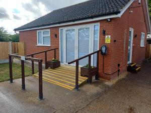 a brick house with a staircase leading to a porch at Ives End in Buxton