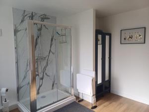 a glass shower in a room with a white chair at Ives End in Buxton +9 photos