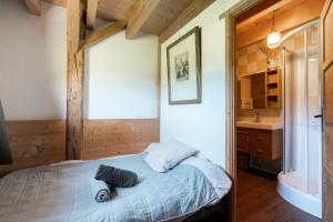 a bedroom with a bed and a bathroom with a sink at Le chalet d'en ô in Les Clefs