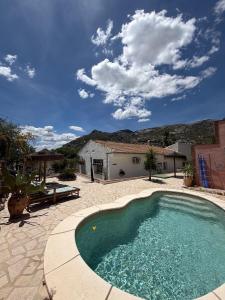 a swimming pool in a yard with a house at Casita Malacitano, Caminito del Rey in Valle de Abdalagís