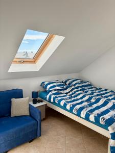 a bedroom with a bed and a blue couch at Tomaszówka in Sarbinowo