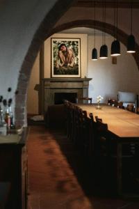 a dining room with a table and a fireplace at Holistic Hotel MadreSelva in Casole dʼElsa