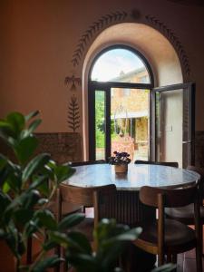 a table and chairs in a room with a window at Holistic Hotel MadreSelva in Casole dʼElsa