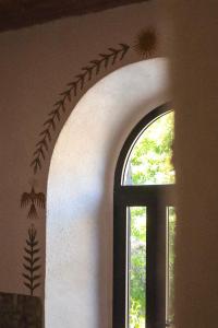 a room with a window and a wall with aigraphy at Holistic Hotel MadreSelva in Casole dʼElsa