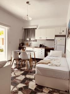 a bedroom with a bed and a table and a kitchen at Alkisti's seaside apartments in Pythagoreio