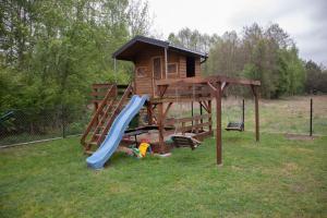 a playground with a slide and a play house at Domek letniskowy in Klusek Biały