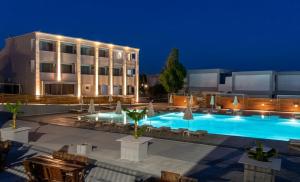a swimming pool in front of a building at night at Pals Studios Pefkos in Pefki