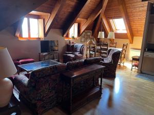 a living room with a couch and chairs and a table at La Buhardilla - Benasque in Benasque