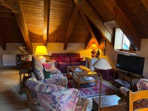 a living room with a couch and a tv at La Buhardilla - Benasque in Benasque