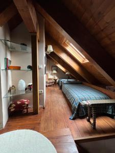 a bedroom with a bed and a wooden ceiling at La Buhardilla - Benasque in Benasque