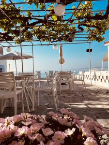 a patio with tables and chairs and the ocean at Alkisti's seaside apartments in Pythagoreio