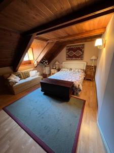 an attic bedroom with a bed and a couch at La Buhardilla - Benasque in Benasque