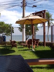 a patio with a table and an umbrella at RESONAMUH - Hostel in São Pedro da Aldeia