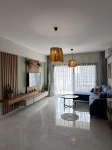a living room with a blue couch and a table at Caesar Resort & SPA - Apartments with 1 Bedroom in Iskele
