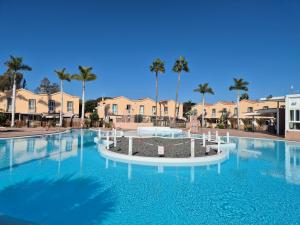 a swimming pool at a resort with palm trees at Bungalow Gran Canaria Oasis in Maspalomas
