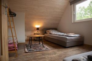 a room with a bed and a table and a ladder at Domek letniskowy in Klusek Biały