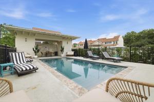 a swimming pool with chairs and a fence at Spacious 3BR - Pool - Beach Nearby in Pass Christian