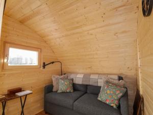a living room with a couch in a log cabin at Little Oaks in Dingwall