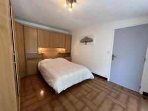 a bedroom with a white bed and wooden cabinets at Fréjus Plage - 5mins à pied des plages - Maisonette avec jardin, 4p, au calme absolu in Fréjus