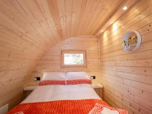 a bedroom with a bed in a wooden room at Little Oaks in Dingwall