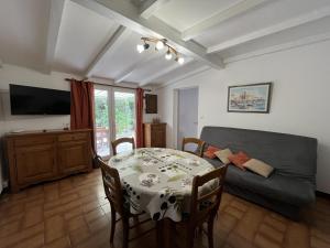 a living room with a table and a couch at Fréjus Plage - 5mins à pied des plages - Maisonette avec jardin, 4p, au calme absolu in Fréjus