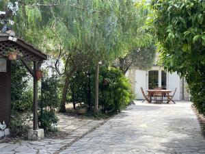 a garden with a table and trees and a patio at Fréjus Plage - 5mins à pied des plages - Maisonette avec jardin, 4p, au calme absolu in Fréjus