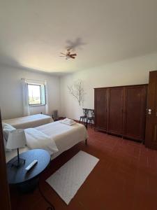 a bedroom with two beds and a ceiling fan at Casa do Cardal in Casével +34 photos