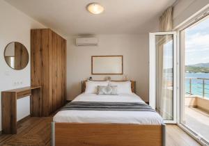 a bedroom with a bed and a large window at Отрада in Utjeha
