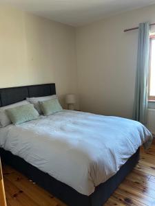 a bedroom with a large bed with blue sheets and a window at Fanore Apartment 3 in Fanore