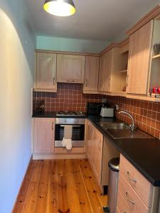 a kitchen with wooden cabinets and a stove top oven at Fanore Apartment 3 in Fanore