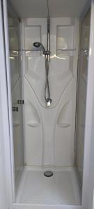a white shower with a shower head in a bathroom at Gasthaus Stausee in Innerthal