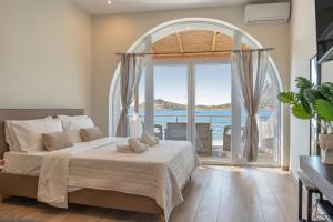 a bedroom with a bed and a large window at Next to the wave in Myrties