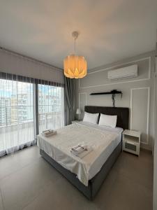 a bedroom with a large bed and a chandelier at Caesar Resort & SPA - Apartments with 1 Bedroom in Iskele +190 photos