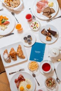 a table with plates of breakfast food on it at Hotel Miramonti Corvara in Corvara in Badia +17 photos