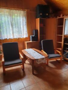a living room with two chairs and a wooden table at Domek letniskowy in Rogówko