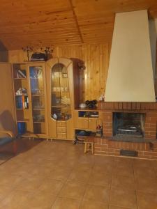 a living room with a brick fireplace and wooden walls at Domek letniskowy in Rogówko