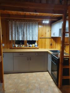 a kitchen with a stove and a window in it at Domek letniskowy in Rogówko