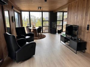 a living room with a tv and a table and chairs at Stryn Nature Lodge in Stryn