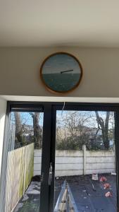 a clock on the wall above a window at House Sleeps 6 with Parking in Coad