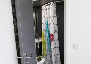 a bathroom with a sink and a shower curtain at STUDIO COSY PROCHE PLAGE, tout à pied in Pornichet