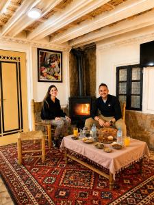 a man and woman sitting in a living room with a table at Auberge des peupliers Café Restaurant in Akhendachou nʼAït Ouffi +63 photos
